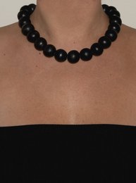 Bold black beaded necklace with round, spherical beads.