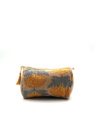 Gold and gray patterned cylindrical toiletry bag with tassel zipper, geometric design.