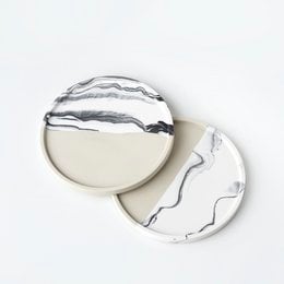 Beige and white round trinket tray made of jesmonite material with a marbled pattern.