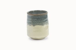 A ceramic cup with a mottled green and white glaze, featuring a cylindrical shape.