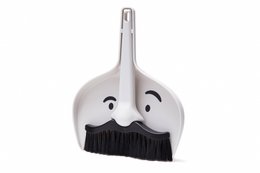 A white dustpan with a mustache-shaped handle and a black brush. The dustpan has a playful, whimsical design that adds a touch of fun to cleaning up.