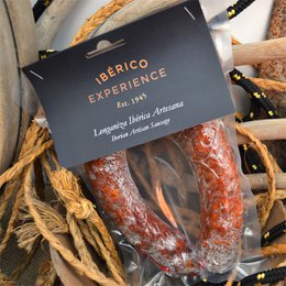  Two artisanal Iberian chorizo sausages, cured and packaged in a black and white label. The sausages have a deep red color and appear to be made from high-quality pork.