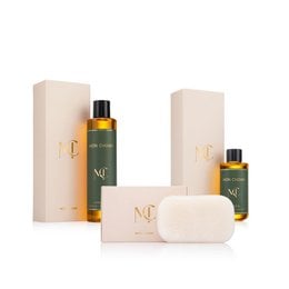 Luxury skincare gift set with golden oil bottles, cream, soap bar, beige packaging, natural botanical ingredients.