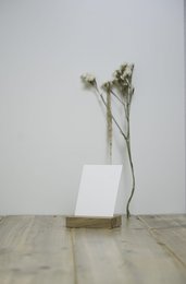 A small wooden holder displaying dried floral stems on a wooden surface.