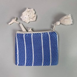 Small handmade blue and white striped clutch bag with tassels.