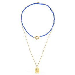 Blue beaded choker necklace with gold pendant charm.