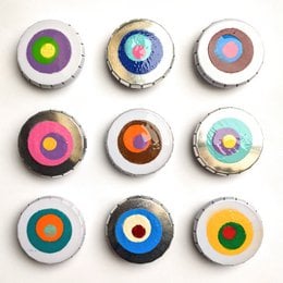 The product appears to be a set of colorful, circular storage boxes or containers. The description includes the product title "CLICK-BLOCK-DESULTS 9ER-PLIFY, MOTRIBUTION "Retroblous"" and the category "Storage Boxes". The images show a variety of circular designs with different color patterns, including concentric circles, abstract shapes, and geometric patterns. These storage boxes could be used to organize and store small items in a visually appealing way.