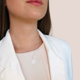 Silver necklace with circular pendant featuring a fork and knife symbol, suitable for casual or formal wear.