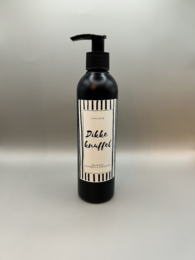 Shower gel with a black and white striped bottle design, featuring the text "Dikke knuffel" which means "Big hug" in Dutch.