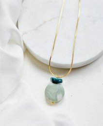 Contrasting celadon and teal pendant necklace with a natural stone charm.