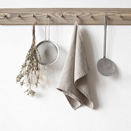 Natural linen kitchen towel with neutral color and rustic style. Absorbent and durable material suitable for everyday kitchen use.