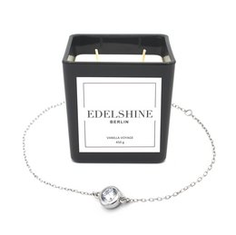Large scented candle with a casual silver bracelet featuring a round charm.