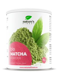Organic matcha powder in a white container with green leaves. Matcha is a finely ground powder made from high-quality green tea leaves. It is a popular superfood known for its antioxidant properties and potential health benefits.