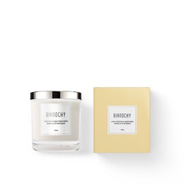 Tall, round white candle with African vanilla scent, presented in a simple glass container with a silver lid.