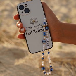 Smartphone case with beaded charm featuring a shell design and the text "The little mermaid's fantails".
