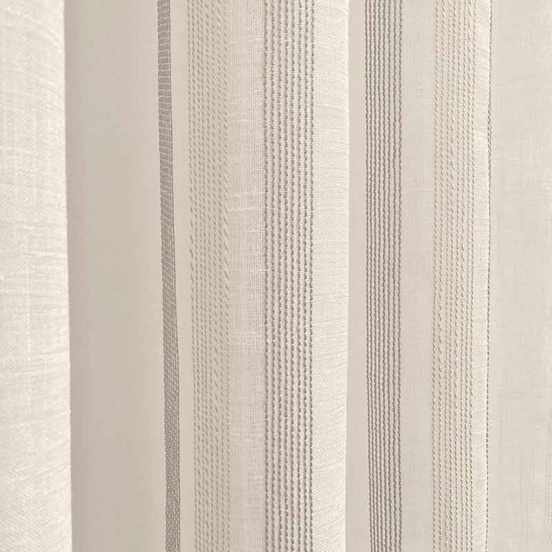 Cortina translúcida de color gris confeccionada en ollados. Visillo Jacquard de rayas vertikale fabrikation med materialer reciclados og calidad. Naturlige farver og kalidos. Cortinas para salón, dormitorio y cocina.