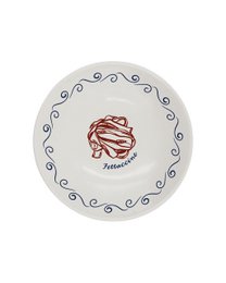 A round, white dinner plate with a green scalloped edge and a green illustration of a person in a relaxed, vacation-inspired pose.