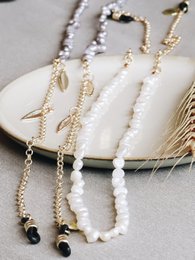 White or gray pearl-beaded spectacle cord with feather accents. Adjustable length for sunglasses or eyeglasses.
