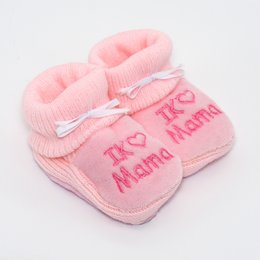Soft, plush pink slippers with "I love mom" text, perfect for young children.