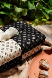 Black and white geometric patterned tissue box holder, rectangular shape, decorative home accessory with diamond print design.