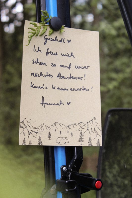 Camper con blocco note in carta erba in montagna
