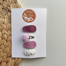 A set of purple and white hair clips made of leather and other materials, suitable for kids.