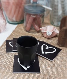 Black and white coasters with text "Koffie tijd" and "Lekker genieten" in a minimalist design.