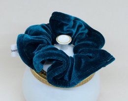 Blue velvet scrunchie with a round, textured shape.