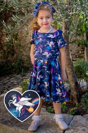 "Girls' 50s inspired swing dress in a unicorn print, available in sizes 3-4 years to 11-12 years. The dress features a round neckline, short sleeves, and a flared skirt."
The product is a girls' 50s inspired swing dress in a unicorn print. The dress has a round neckline, short sleeves, and a flared skirt. It is available in sizes ranging from 3-4 years to 11-12 years.