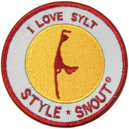 Circular patch with text "I LOVE SYLT" and an illustration of a bird. The patch has a red border and a yellow background.