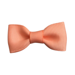 Peach pink bow hair clip for babies, made of soft, ribbed material.