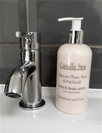 Damson plum, rose, and patchouli scented hand and body lotion in a 250ml bottle with a chrome pump dispenser.