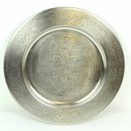 A round, silver-colored serving tray with an intricate, ornate pattern engraved on the surface. The tray appears to be made of metal and has a diameter of approximately 40 cm.