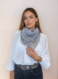 Soft, cozy scarf in a speckled gray and pink pattern with tasseled edges, perfect for adding a touch of style to any outfit.