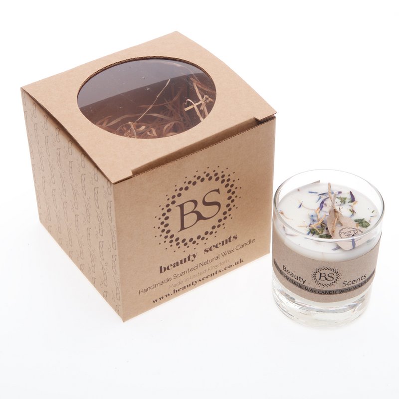 Petite bougie de soja parfumée avec des fleurs sauvages dans un récipient en verre