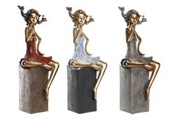 A resin figure depicting a stylized female figure in three different color variations - red, silver, and gold. The figure has an abstract, artistic design with flowing hair and a seated pose.