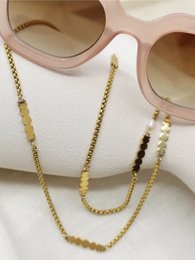 Gold-tone sunglasses cord with shell-shaped charms. Adjustable length, suitable for various sunglass styles.