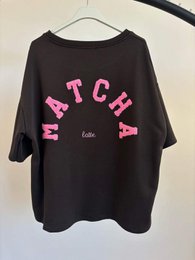 Black oversized t-shirt with pink "MATCH" text graphic print, short sleeves, casual style.