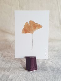 Aubergine-colored ceramic card holder with a geometric design.