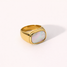 Gold statement ring with a large square-shaped white stone.