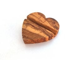 Heart-shaped olive wood smartphone stand with striped pattern.
