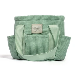  A mint green corduroy grooming bag with multiple pockets and compartments, suitable for storing horse grooming supplies.