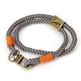  A grey and orange woven bracelet with a metal clasp. The bracelet has a braided rope-like texture and features a mix of grey and orange colors.