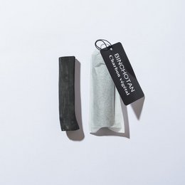 Organic binchotan charcoal water filter, black in color, used to purify and filter water.