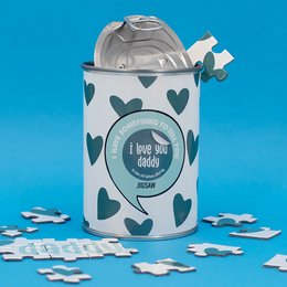 "A patterned tin can with a heart design and the text 'I love daddy' on the label. The can is surrounded by puzzle pieces, suggesting this is a puzzle product."