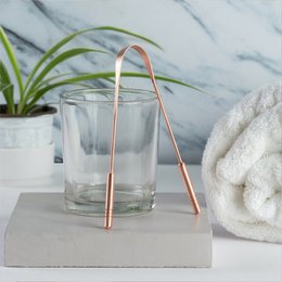 Copper tongue cleaner with a curved, elongated shape and a metallic copper finish.