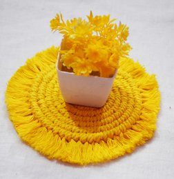  Yellow handwoven cotton coasters with textured circular pattern, natural beige center, decorative fringe edges.