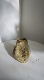 A handmade, matte gray vase with a simple, cylindrical shape.