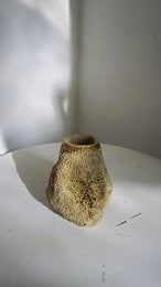 A handmade, matte gray vase with a simple, cylindrical shape.