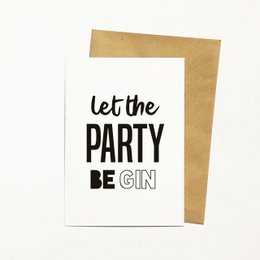 A white greeting card with the text "Let the PARTY BE GIN" in bold black lettering. The card is surrounded by colorful cotton balls, creating a festive and celebratory atmosphere.